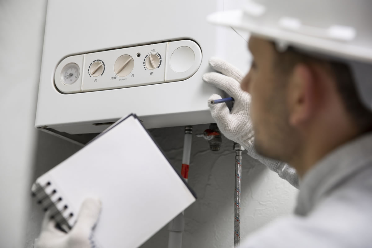 Engineer setting hot water boiler temperature to kill Legionella