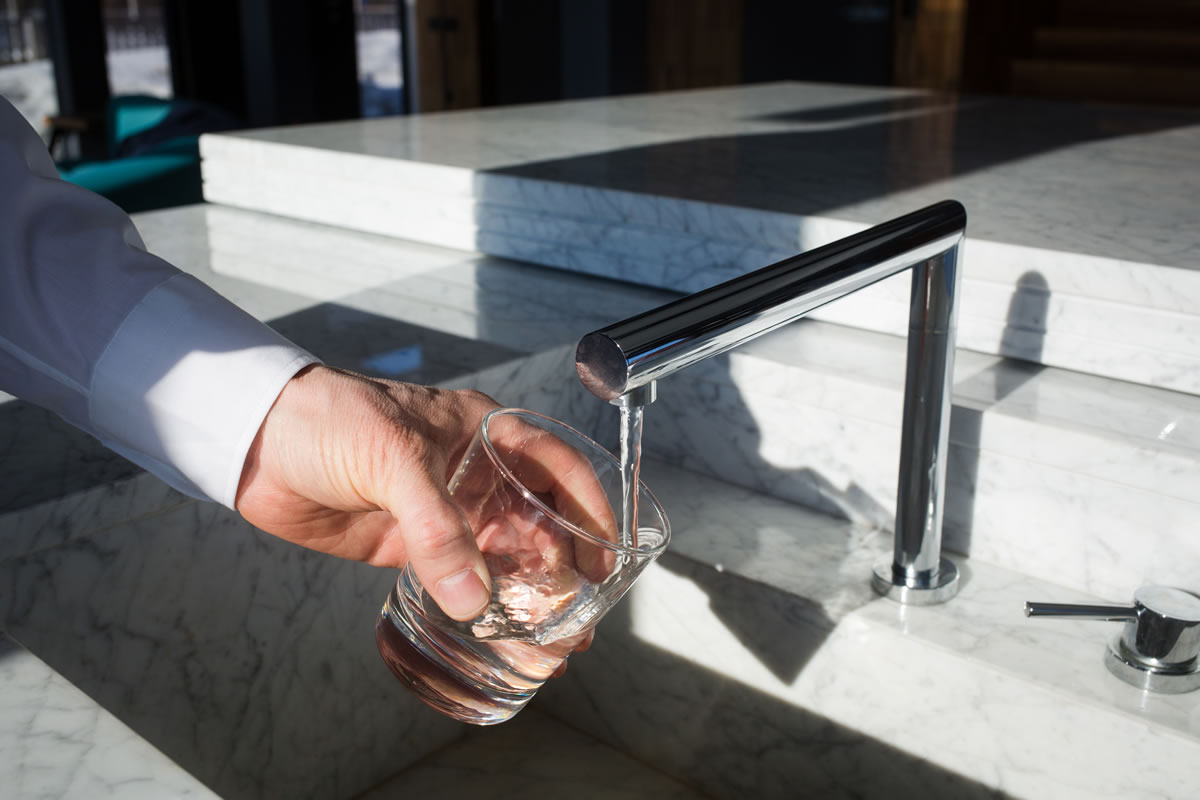 Man filling glass with drinking water in commercial building