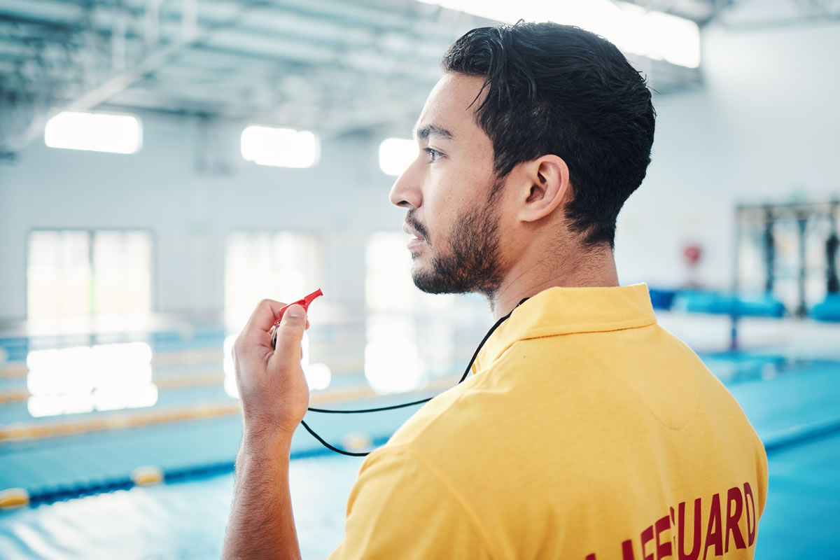 Lifeguard providing health and safety for indoor swimming pool Lifeguard providing health and safety for indoor swimming pool