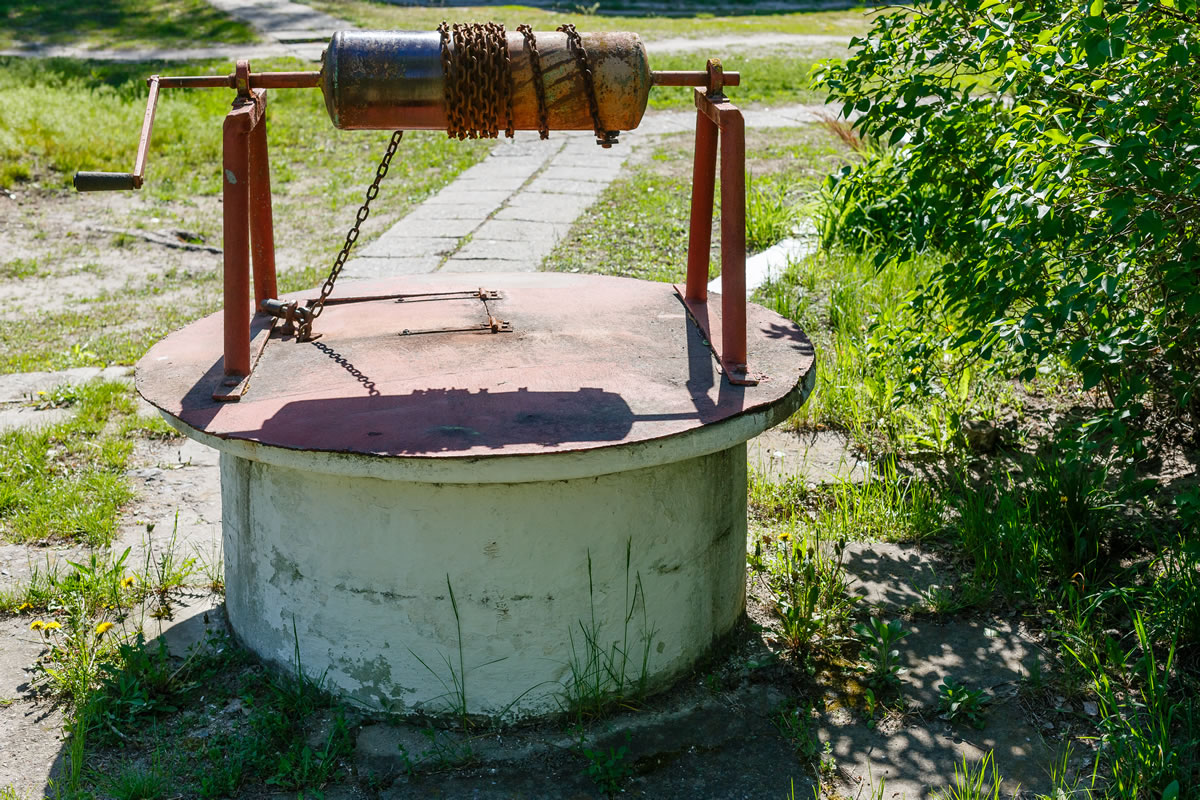 Old domestic drinking water well with metal cover